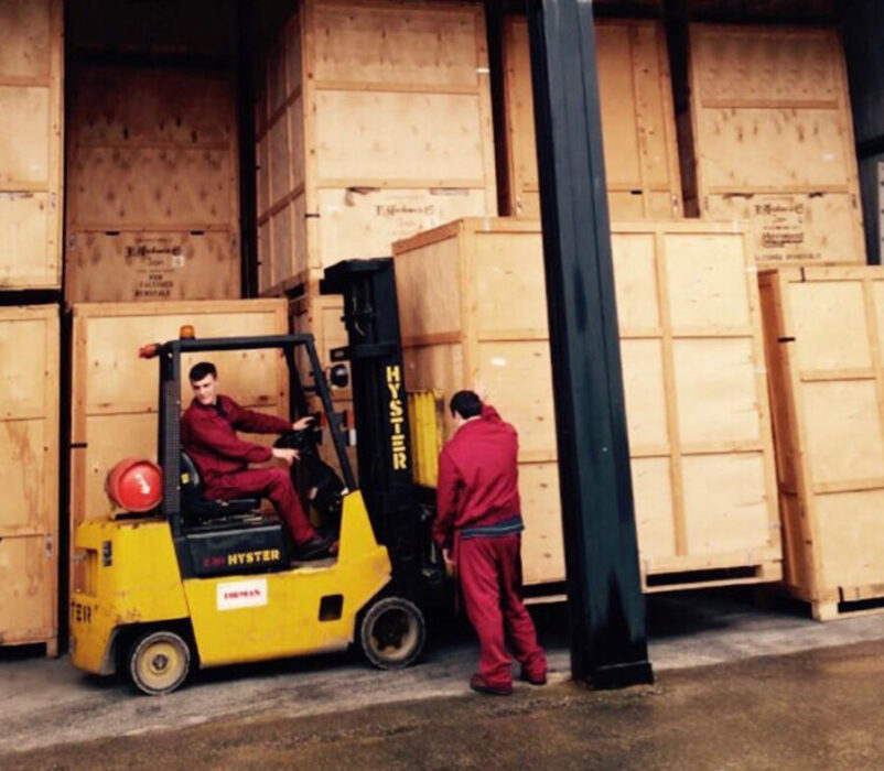 Worker driving forklift in a furniture storage facility in Swansea.