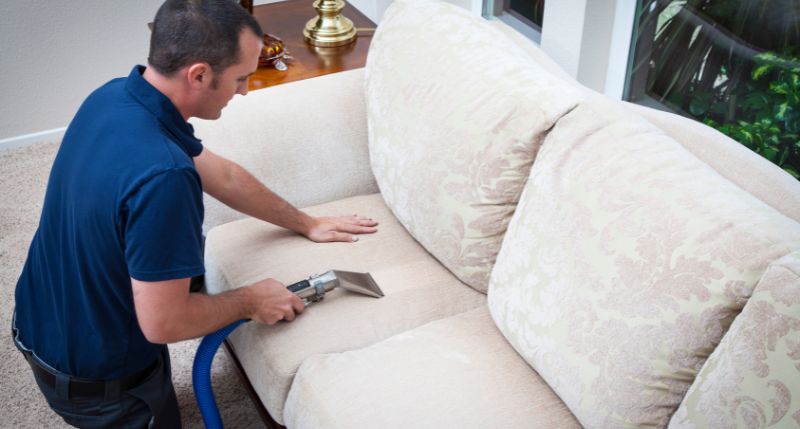 A person cleaning furniture to keep it safe in storage.